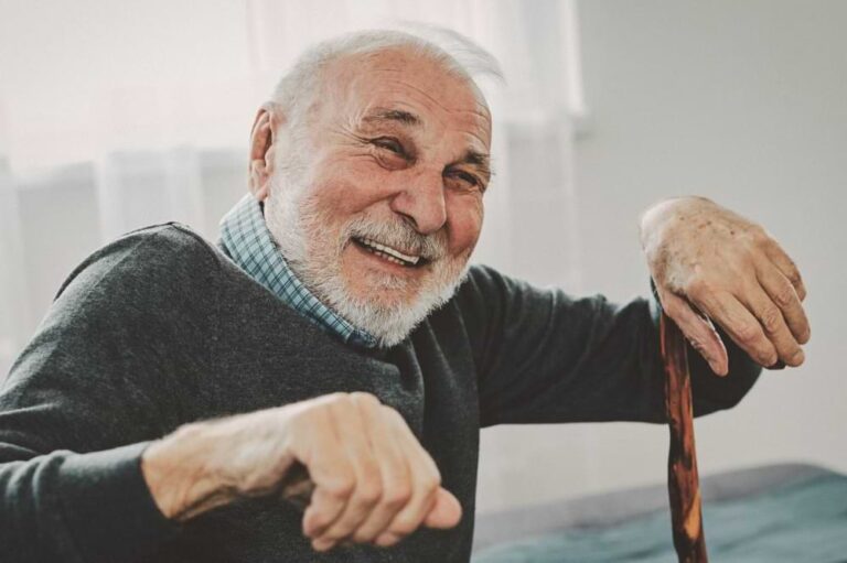 Smiling man with a cane.