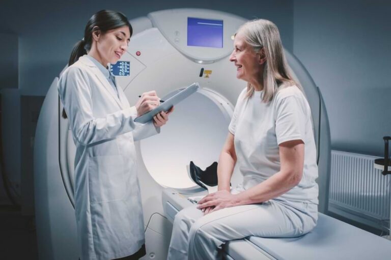 Healthcare provider consulting with patient outside of MRI machine.