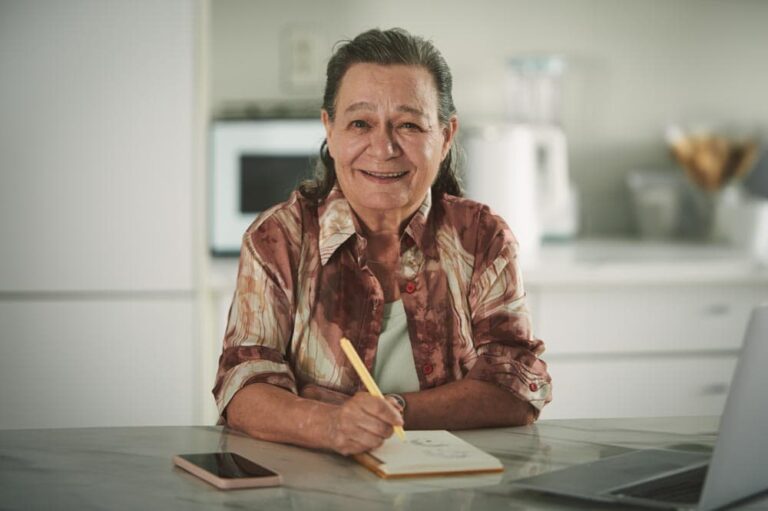 A woman writing in her kitchen.