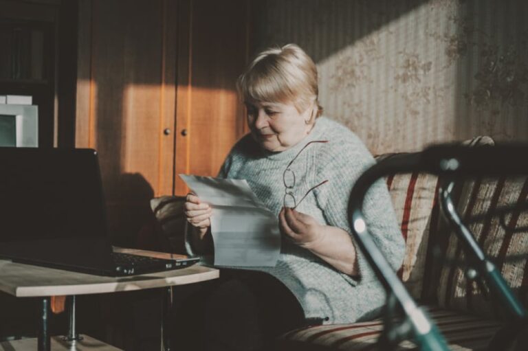 Woman reading a document at her kitchen table.