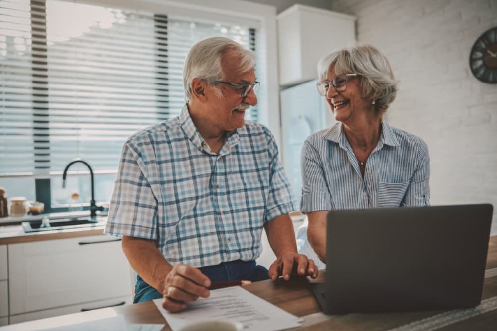 Couple laughing at computer.