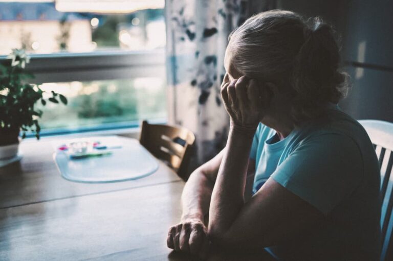 Sad woman sitting at table.