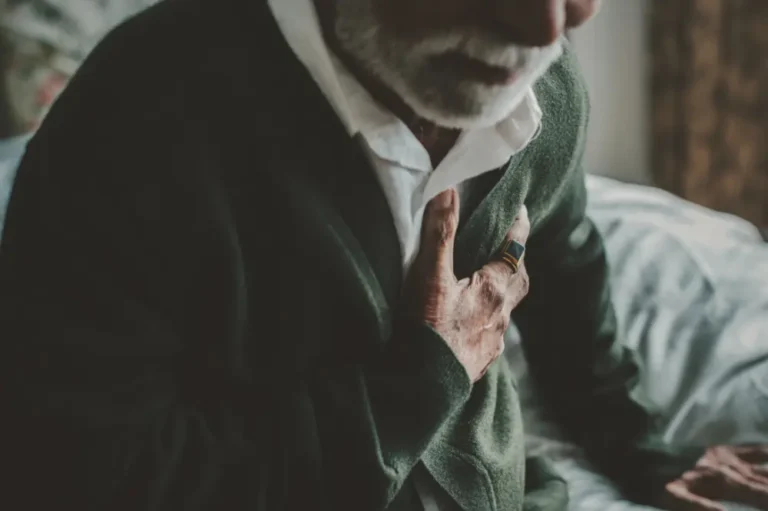 Man clutching chest due to chronic diastolic heart failure.